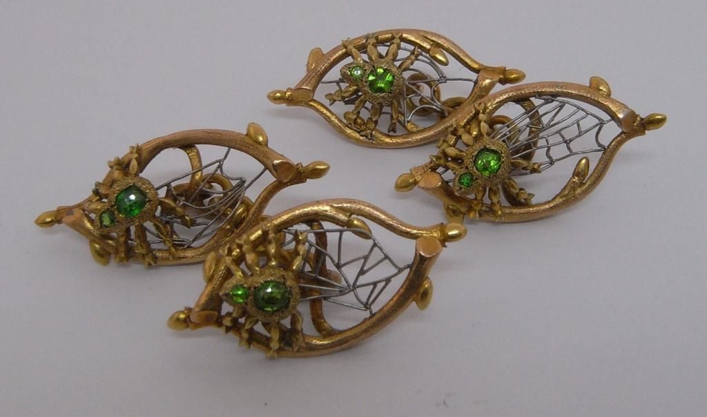 An unusual set of early 20th Century Russian gold and platinum spider and web links.  Each designed as a spider set with two demantoid garnets.  On a platinum web spun between two stylised gold twigs.  Each link marked '72' for 18kt gold.  Cased.