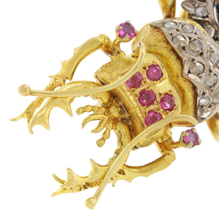 This beautifully enameled insect brooch is set with 1.0 carats of rose cut diamonds and .80 carats of natural ruby. Finely fabricated in 14k yellow and white gold, it is in the form of a colorful stag beetle.

Remarks from Lawrence Jeffrey: