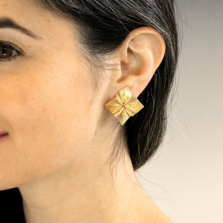 In these chic 18k gold earrings Tiffany’s love affair with ribbon motifs tastefully collides with mid-century handkerchief designs. Suggestive of grosgrain ribbon fabulously fashioned as if gathered to the center, these earrings are modern, organic,
