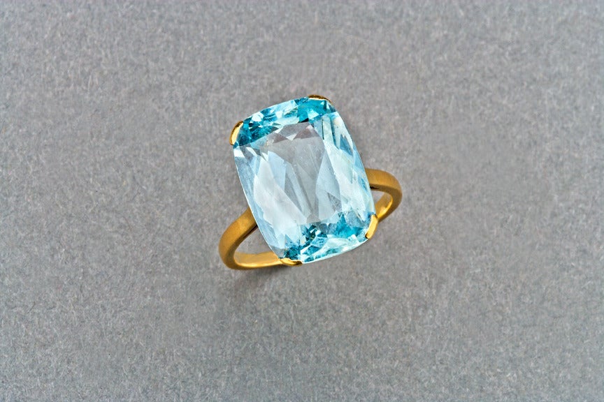Set with a cushion-cut aquamarine weighing approximately 11.7 cts, mounted in 18k gold.