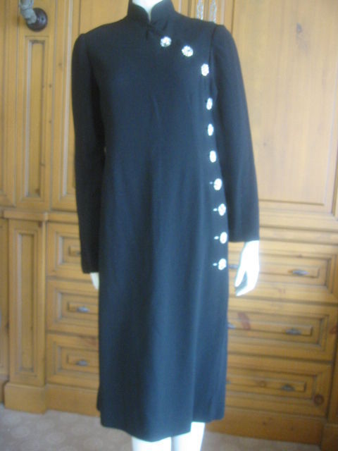 Charming high collar black dress from Norman Norell.<br />
Dramatic large crystal buttons up the side<br />
Bust 40