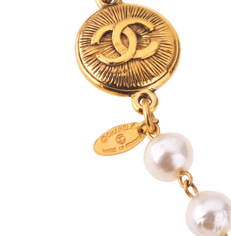Chanel classic long pearl necklace with CC coin motif.