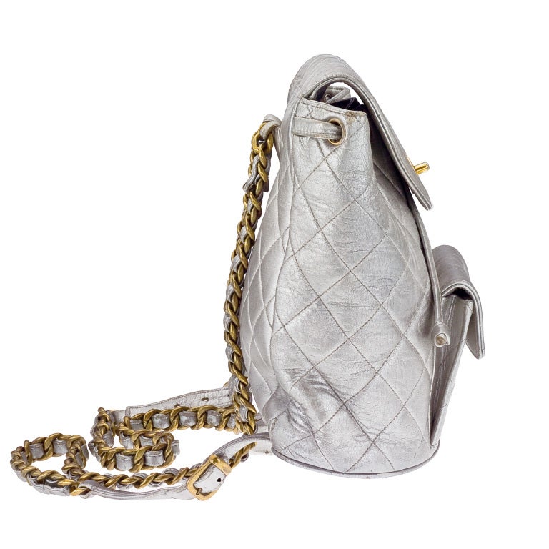 Vintage Chanel mini backpack in silver metallic with gold hardware.