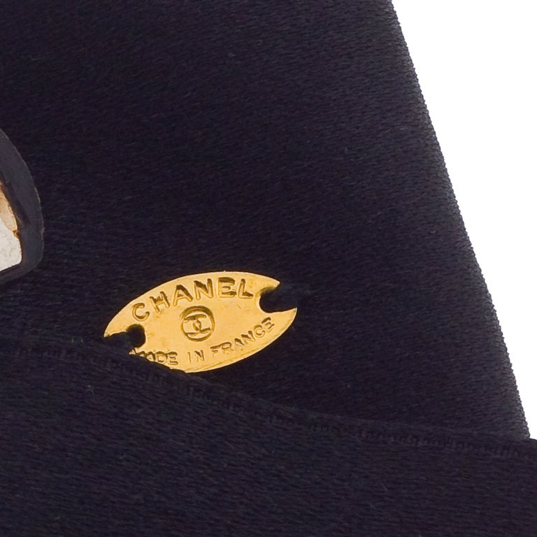 Very rare Chanel black bow hair barrette with gold toned CC logo motif.