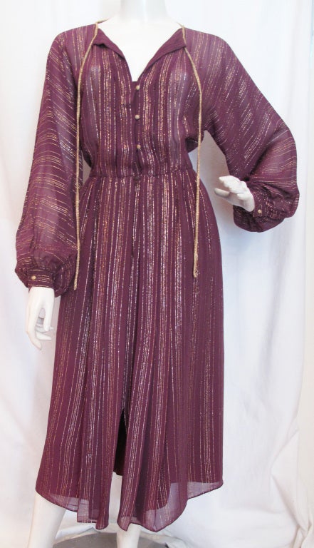 Please contact dealer prior to purchase for White Glove shipping options.

FRANK TIGNINO Purple Gown with Gold Thread.

Beautiful gown with small gold buttons up shirt and on wrists. Gold ties at neck and slit to the knee. 

The promise of