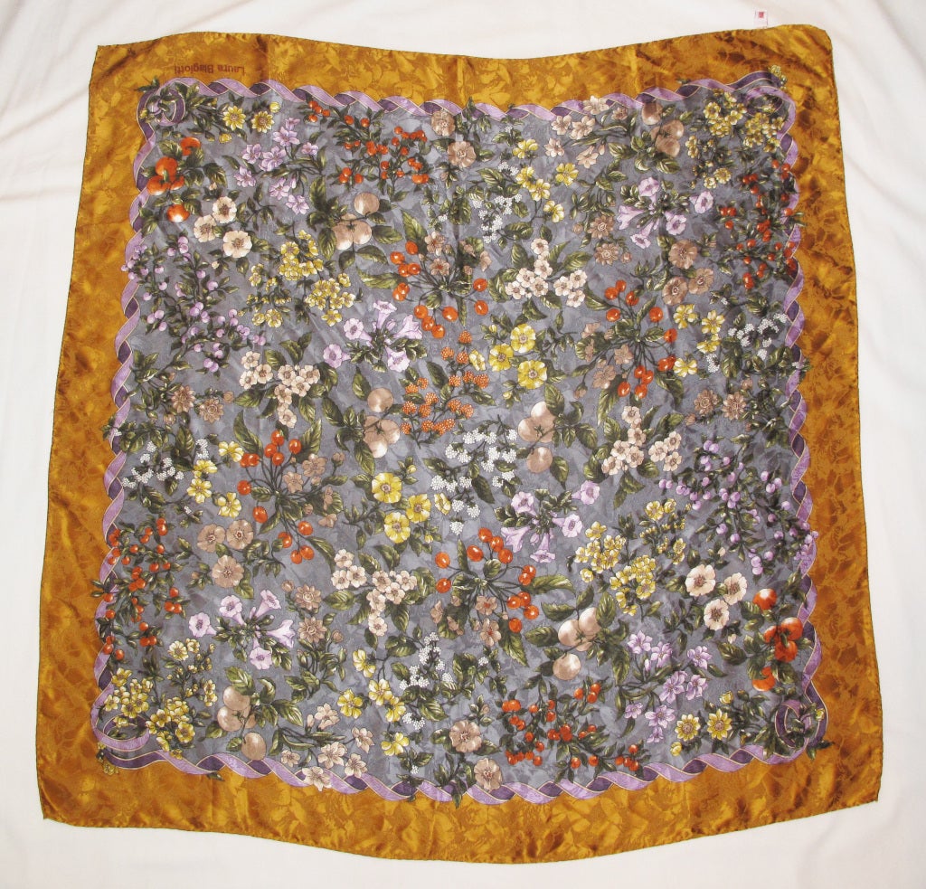 Please contact dealer prior to purchase for White Glove shipping options.

Beautiful Fruits and Florals Extra Large Silk Floral LAURA BIAGIOTTI Scarf in Gold, Lavender, and Grays.