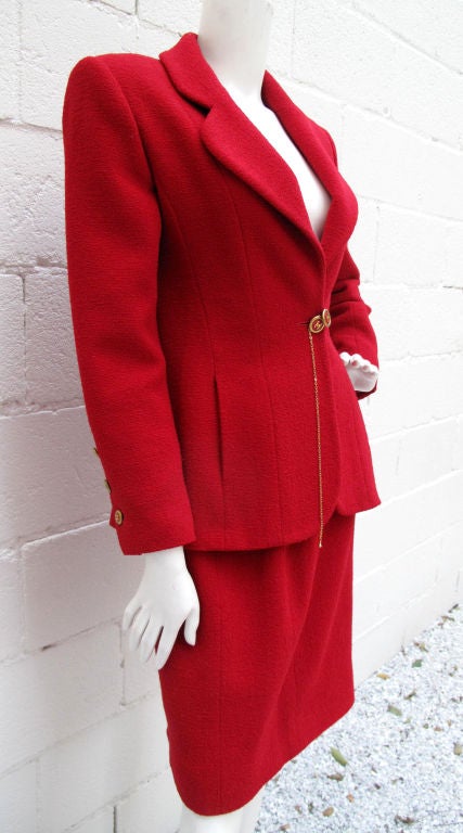 Red CHANEL skirt suit with logo button & chain closure. Originally sold at Bergdorf Goodman. Lined with logo and classic chain along the bottom lining of jacket.<br />
<br />
Waist, Hip, and Length measurements taken from skirt.<br />
<br