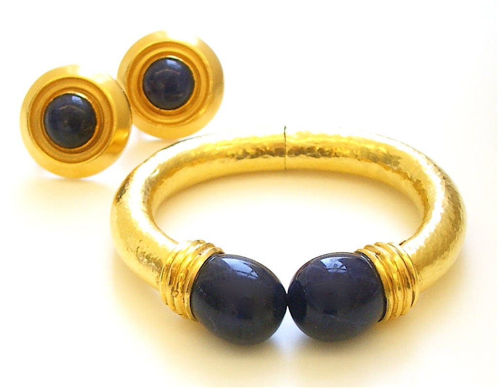 A handsome 18k yellow gold and sodalite bangle bracelet by Ilias Lalaounis. The hammered torque style bracelet culminating in Lapis colored sodalite terminals.Signed Lalaounis. Looks great with similar ear clips also on the site. Smart.Fits a wrist