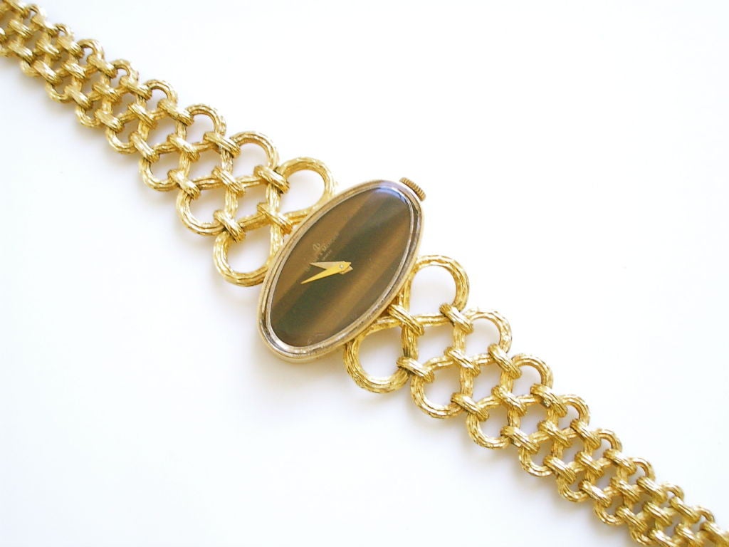 A stylish 14k yellow gold and tiger's eye timepiece by Baume and Mercier. The 1 1/8