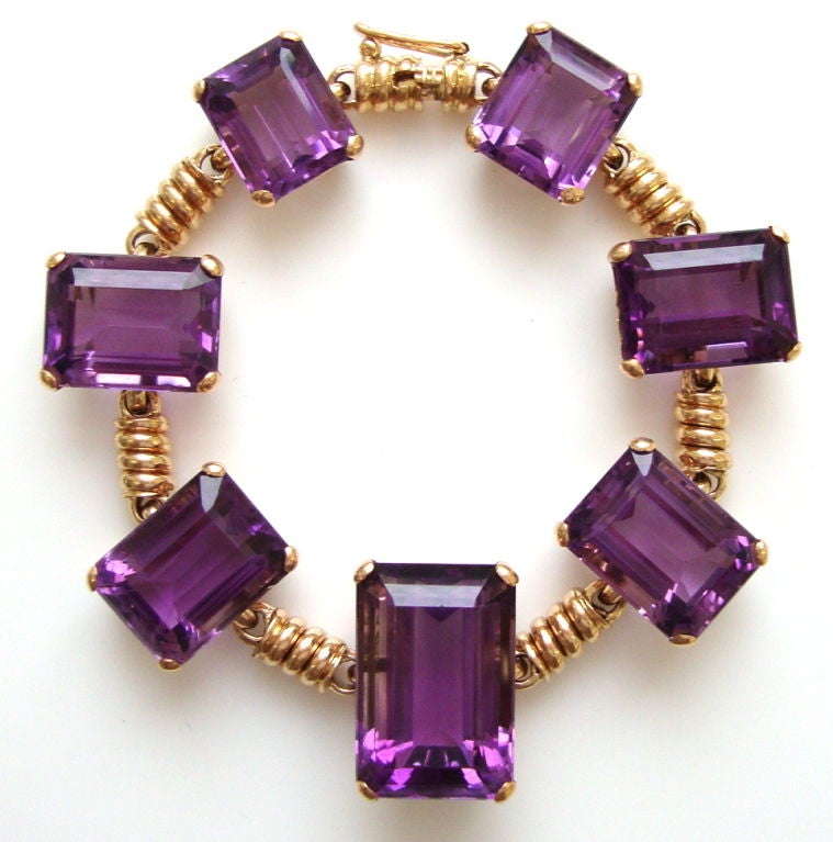 A smart yellow gold and amethyst bracelet. The 18k warm yellow gold bracelet with seven deeply saturated purple amethysts ranging in size from 21 x 14mm to 12.8 x 11.mm connected by spiral wire-work links. An attractive piece of retro jewelry.