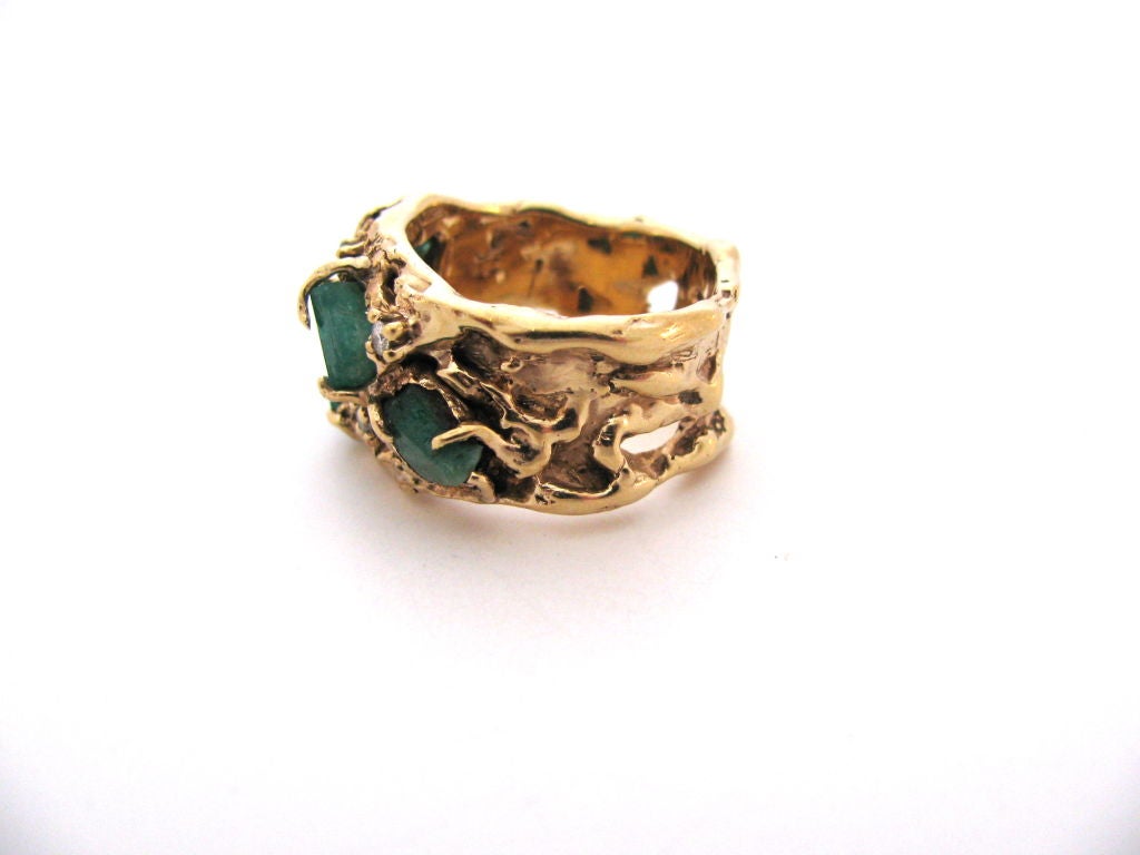 A fashionable gold emerald and diamond ring by Arthur King. The handcrafted 5/8