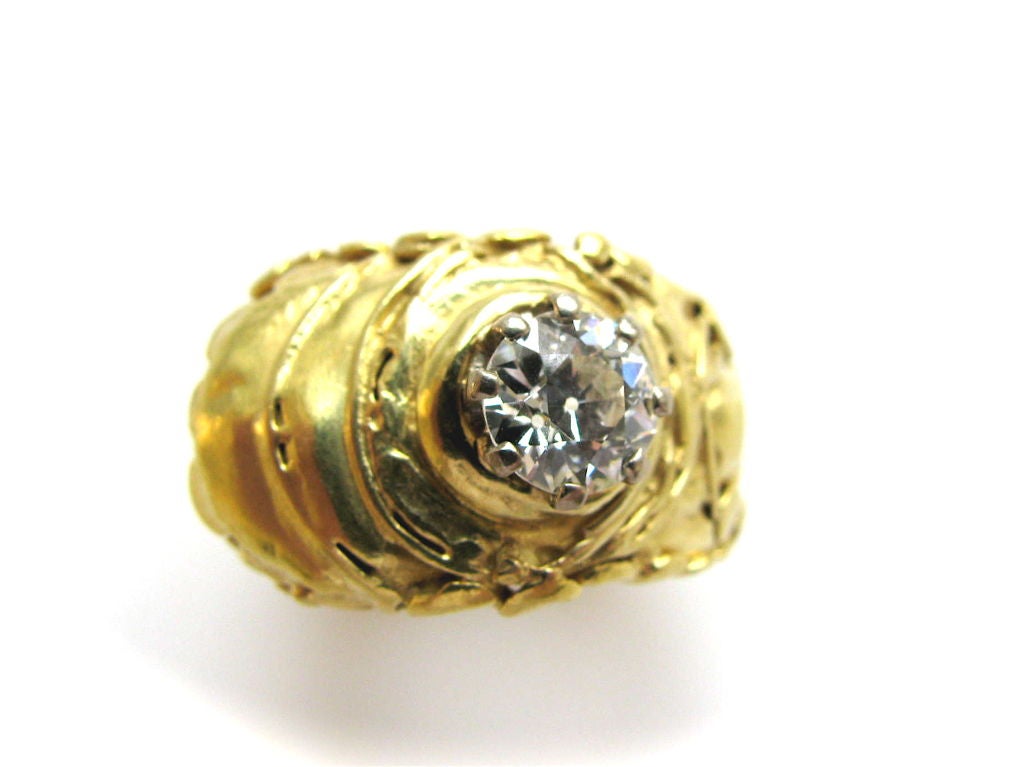 An artistic diamond solitaire ring.. The 18k yellow gold and diamond ring in the brutalist style. The European-cut diamond weighing just under 1.00 carat ,of G-H color and vs clarity set in a 1/2