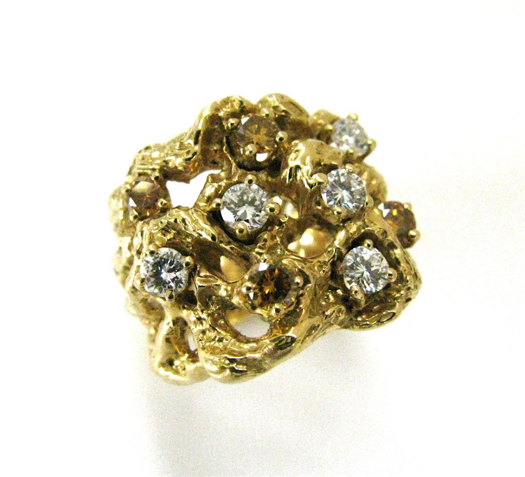A good looking gold and colored diamond ring by Arthur King. The 18k yellow gold freeform band with white, golden and cognac Round diamonds. A handsome and wearable ring. King, a self taught artisan , began his career in Greenwich village. His