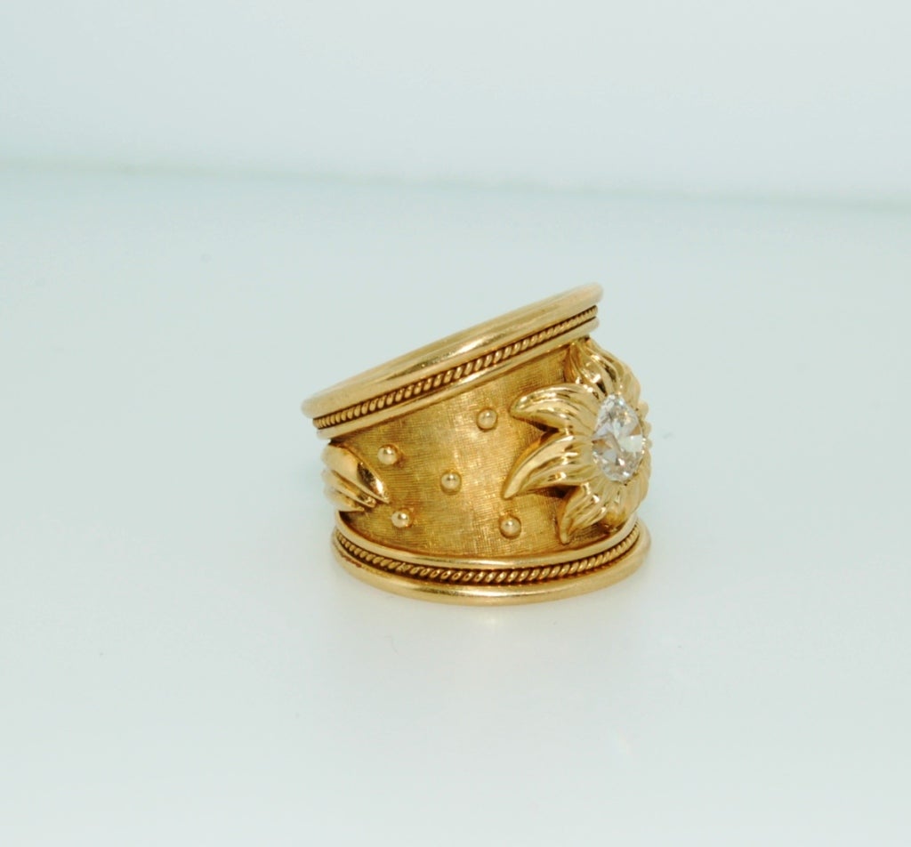 Gorgeous 18K yellow gold tapered templar ring, featuring 0.85 carat round brilliant diamond, with flower designed surround. The ring is decorated with gold bead detail and is finished with a wire twist wire edge. 

Measurement: 19.54 mm wide (