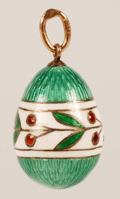 A Faberge gold and enamel miniature pendant egg, workmaster Feodor Affanasiev, ST Petersburg, circa 1900. The green translucent enamel over a textured engine-turned ground encircled by a wide band of opaque white enamel decorated with green leaves