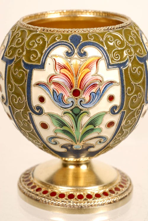 A Russian silver gilt and cloisonne enamel vodka cup, Feodor Ruckert, Moscow, 1896-1908. The bulbous body worked in multi-color stylized foliate cartouches on a cream ground surrounded by olive green enamel set with scrolling filigree wires . The
