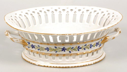 A Russian porcelain pierced fruit basket, Imperial Porcelain Factory, St. Petersburg, period of Paul (1796-1801). The oval fruit basket with handles molded with leaves and scrolls and partially gilded, a central band about the bowl decorated with a