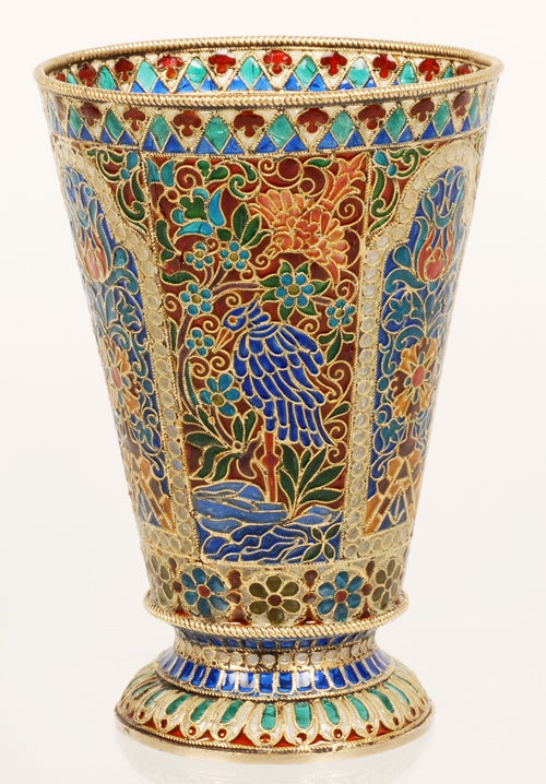 A large Russian gilded silver and plique-à-jour enamel beaker, Ovchinnikov, Moscow, circa 1895. Of tapering cylindrical form, the body decorated with panels depicting flower heads and foliage against a blue ground within white beaded borders,