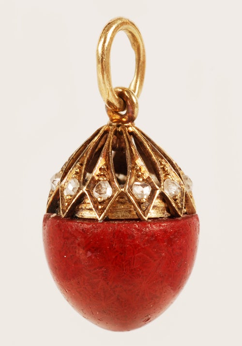 A Faberge gold, gem-set, and purpurine miniature pendant egg, workmaster August Holmstrom, ST Petersburg, circa 1900. The purpurine egg capped by an openwork gold cage set with mine-cut diamonds. Height: 7/8