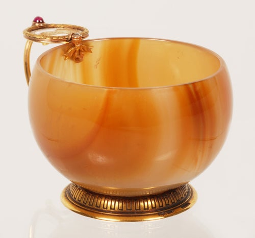 A Fabergé gem-set gold-mounted carved striated agate and enamel cup, workmaster Michael Perchin, Saint Petersburg, late 19th century, with scratched Fabergé inventory number 52147. The carved bulbous bowl fitted with a conjoined C-scroll handle