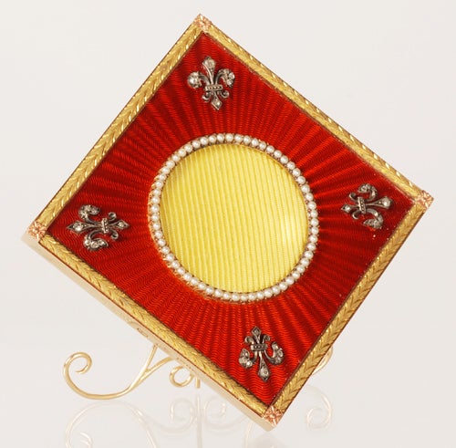 A Fabergé jeweled two-color gold and red guilloché enamel photograph frame, workmaster Henrik Wigström, Saint Petersburg, circa 1903-1908, with original scratched inventory number 11226. Diamond shaped, enameled in translucent red over a sunburst