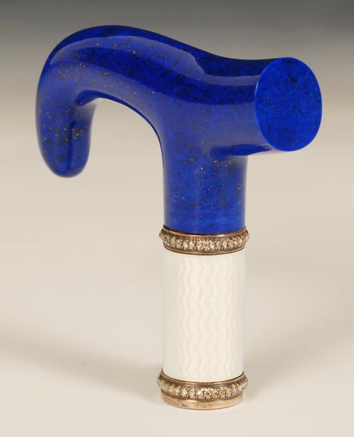 A Faberge jeweled gold mounted and guilloche enamel lapis lazuli parasol handle, workmaster Henrik Wigstrom, ST Petersburg, circa 1908-1917. Of tau form, the mounted collar enameled in translucent white over a wavy engine-turned ground, between