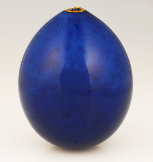 A Russian Imperial Presentation Easter egg, Imperial Porcelain Factory, Saint Petersburg, circa 1900. The blue ground porcelain egg decorated with varicolor ciselé and embossed gilt cypher of Empress Alexandra Feodorovna surmounted by the Imperial