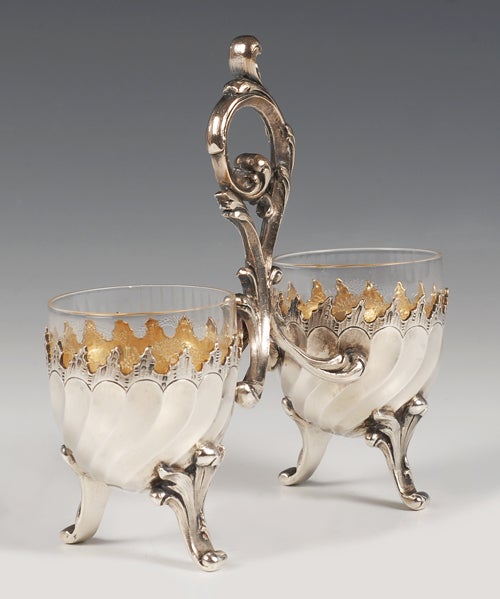 A Faberge silver-gilt double salt, Moscow, circa 1891. The spiral fluted salt with leaf shaped feet and handle, etched glass liners. Height: 4 5/8