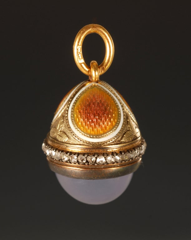 A Faberge gold mounted jewelled enamel miniature pendant egg, workmaster Henrik Wigstrom, ST Petersburg, ca 1905, with scratched inventory number 8605. Of ovoid body with a band of rose-cut diamonds with salmon guilloche enamel roundels and a
