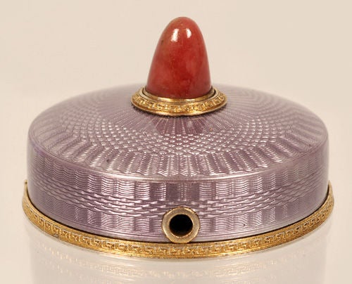 A Fabergé silver gilt, guilloché enamel, and carved rhodonite bell push, workmaster Andrei Adler, Saint Petersburg, circa 1908-1917. Of low circular form, enameled in translucent mauve over a radiating wave engine-turned ground, with gilded silver