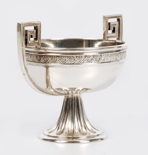 A Fabergé silver two-handled open salt, workmaster Alexander Wäkevä, Saint Petersburg, 1908-1917, with Fabergé scratched inventory number 21008. In Neoclassical taste, the round bowl with anthemia border and Greek key handles, raised on a flaring