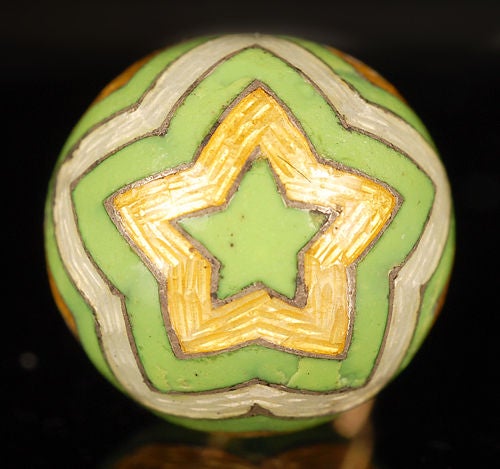 A Russian gold and guilloché enamel miniature pendant Easter egg, almost certainly by Fabergé, Saint Petersburg, circa 1900. Enameled in chevron stripes of opaque green alternating with  translucent white and lemon yellow over hatched grounds, the