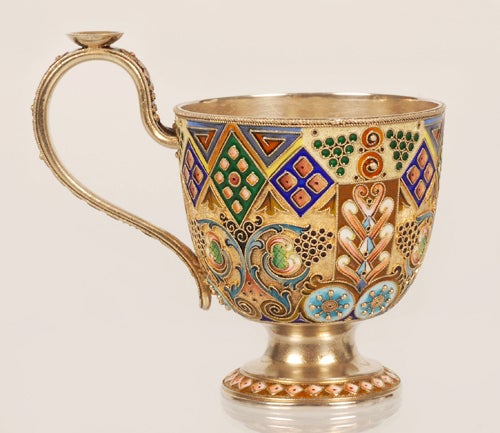 A Russian silver gilt and shaded cloisonne enamel cup and saucer, 11th Artel, Moscow, circa 1908-1917. Both pieces decorated in a multi-color shaded geometric and scrolling foliate motifs all against a stippled ground. Height of cup: 3 1/8