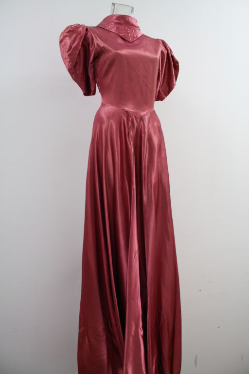 Dusty Rose Joan Crawford Style Dressing Gown. Made from beautiful heavy bridal satin. This long zip front dressing gown has a tie sash. It also has gorgeous structured peplum sleeves. There is an embossed embroidered pattern through out. Pair with a