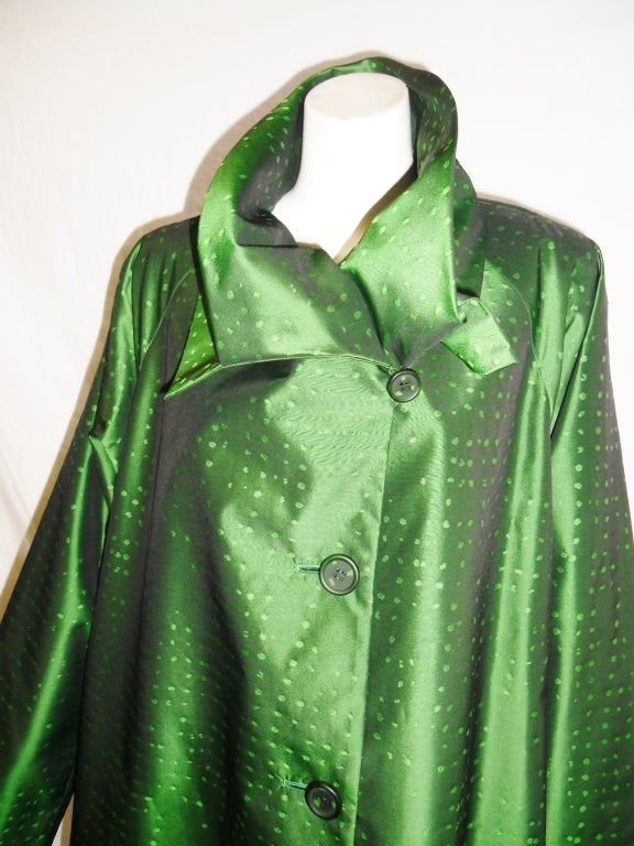 Incredible Issey Miyake green coat with a double pleated collar. 70% Silk/30% Polyester in a fabulous irredescent sprinkled with abstract polka dots in an uneven pattern. Size seam pockets and see-through buttons painted to match. Fully