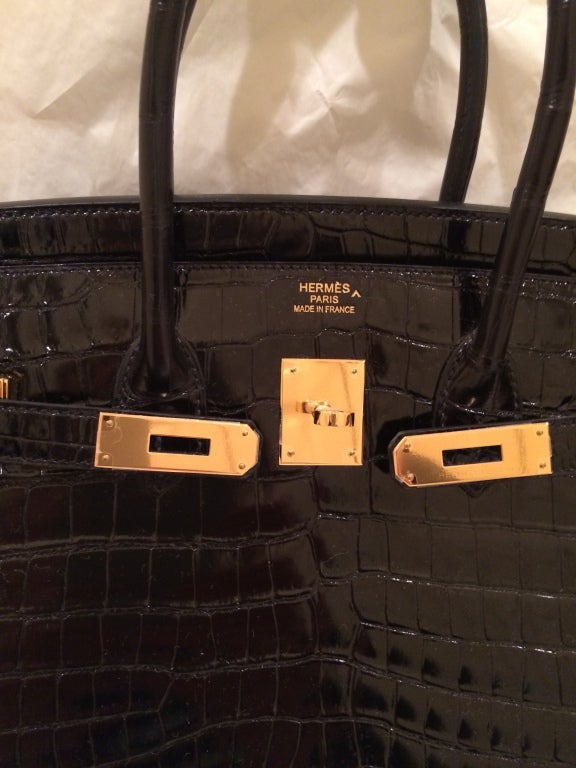 Never carried and totally pristine, this Hermes 35 cm Black Crocodile Birkin is truly spectacular. The protective plastic is intact on the gold hardware and it has been carefully stored with the original Hermes tissue and box. Hermes bags are