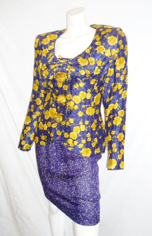 Incredible purple silk chiffon  with yellow roses print . Jacket is delicately quilted with gold metallic thread. Front concealed  double snap closure adorned with three hand made silk rosettes. Sleeves have zipper at the wrist for snug fit. Purple