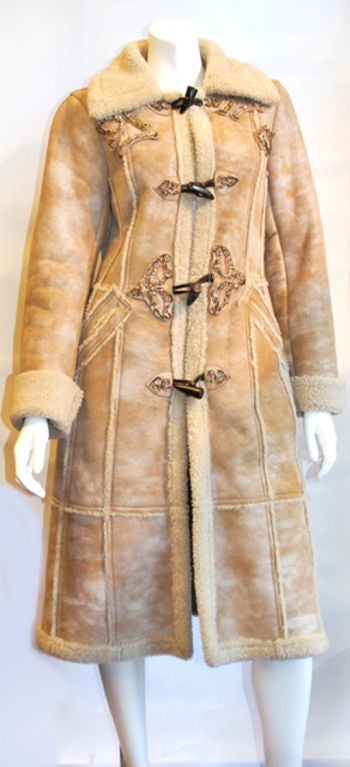 Another almost $6000 hip item   from Italian luxe line Prada. The eternally chic and ever-classic camel color sheepskin  shearling with smart styling and envelope-pushing proportions. Leather appliques with antique gold thread and gold sequent.