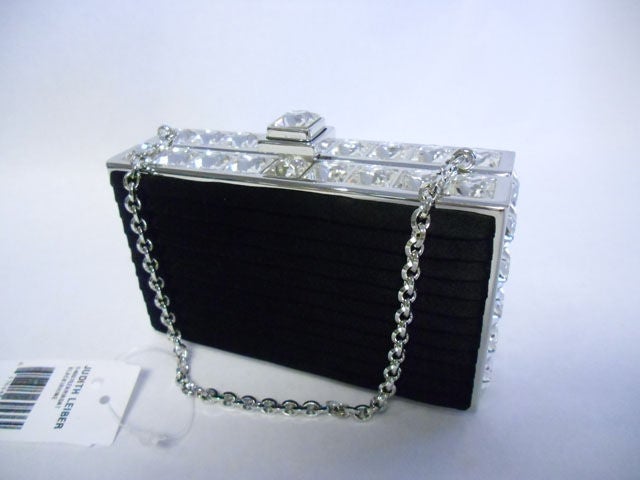 New With tags. Retail  price $2975 beautiful hard case timeless evening bag. Black micro pleated silk with large square clear crystals all around. Silver leather lining. Silver toned  chain. 
Year: New With Tags
