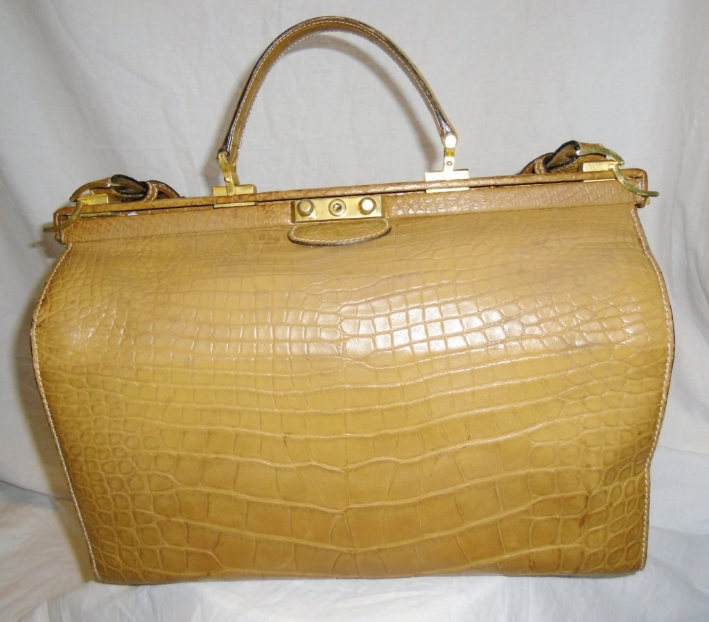 Beautiful tan color Gucci Genuine  Alligator Large Doctor Travelling bag . Lined in suede with name tag and  shoulder strap. Mint condition. Security side brass locks. Bottom protective feet. 
Bag measures 15 X 10 X 8