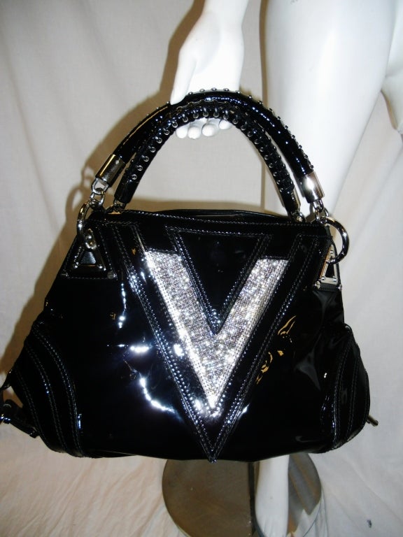 Made in 2008 as a couture line and priced close to $10000 this bag is very rare to find. Never used in absolutely pristine condition. Large v front set in crystals. bag opens up into two parts to show  one middle zipper hidden compartment. Silk