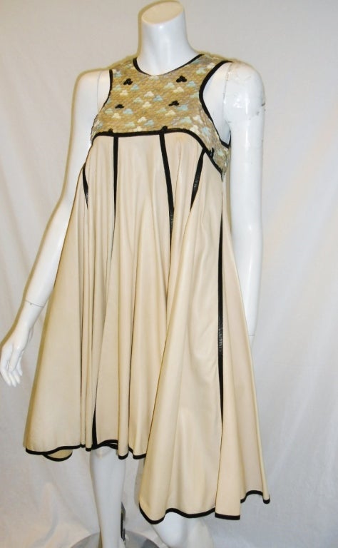 Baby soft nude color dress by Fendi. Beautifully designed top made of leather cut sequent in 3  colors set as a fishscale. Perfect summer dress. Trapeze bottom with uneven hem symmetrically divided with black strips of leather.  Cotton lined. Size 4