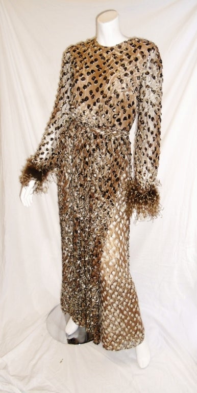 This vintage Oscar De La Renta jumpsuit is from the 70′s.    The palazzo legs ,cinched waist added front and back panels and belt  make this jumpsuit look like a spectacular gown.Extra touch with ostrich feather cuffs. 
Silk chiffon   in