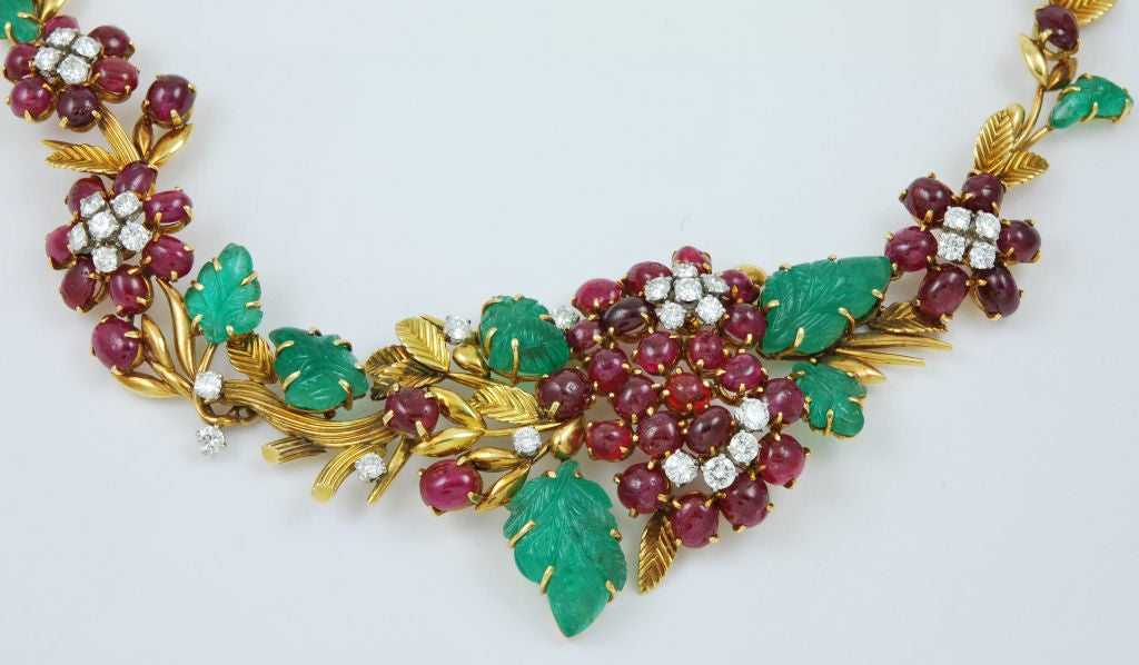 18 KT yellow gold floral motif asymmetrical necklace with vivid cab rubies, richly colored, translucent carved emerald leaves and diamonds and with French stamps, signed 