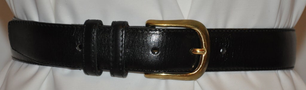 Yves Saint Laurent men's black calfskin leather belt has gold hardware buckle. The inner lining is faced with brown calfskin leather and finished with black top stitching finishing. The men's belt measures 1 1/8