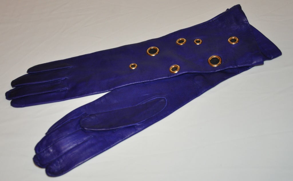 Daniel Silver fr Marie France Deep Violet lambskin gloves is accented with multi-sized ringlets of gold hardware. The gloves are lined with silk in black.
   The gloves are size 7, the length of the gloves measures 14