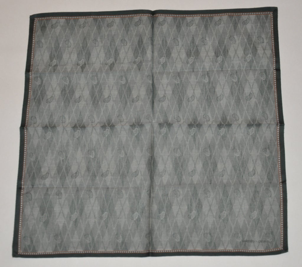 Valentino men's cotton handkerchief has shades of powder greens with diamond and pasley prints. The borders are finished with dark forest green. The measurements are 17