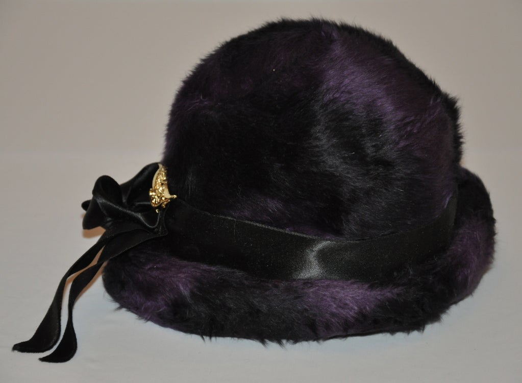 Odetta plum and black wool felted hat id accented with a black silk ribbon and a gold 