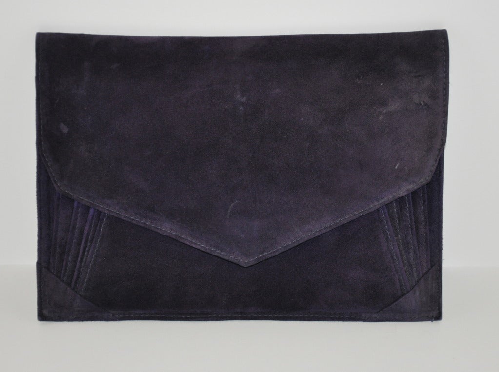 Andrea Pfister deep-Plum suede multi-compartment clutch seems like any typical run-of-the-mill clutch, until opening. When raising the flap, shows three (4) separate compartments with the last compartment having a zippered compartment within.
  