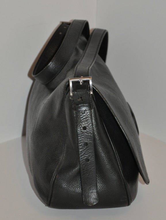 This Prada black textured shoulder bag has a flap including a buckle located at the bottom for added security. The straps can be adjusted if desire. Straps measures 58